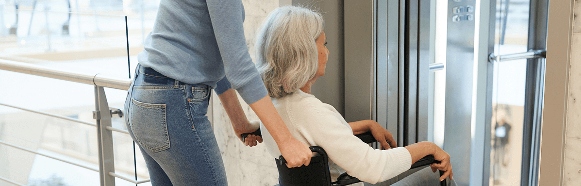 Blog banner image of an elderly woman being assisted